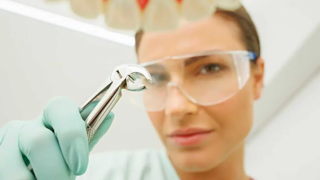 kids dentist carrying out a tooth extraction on a child