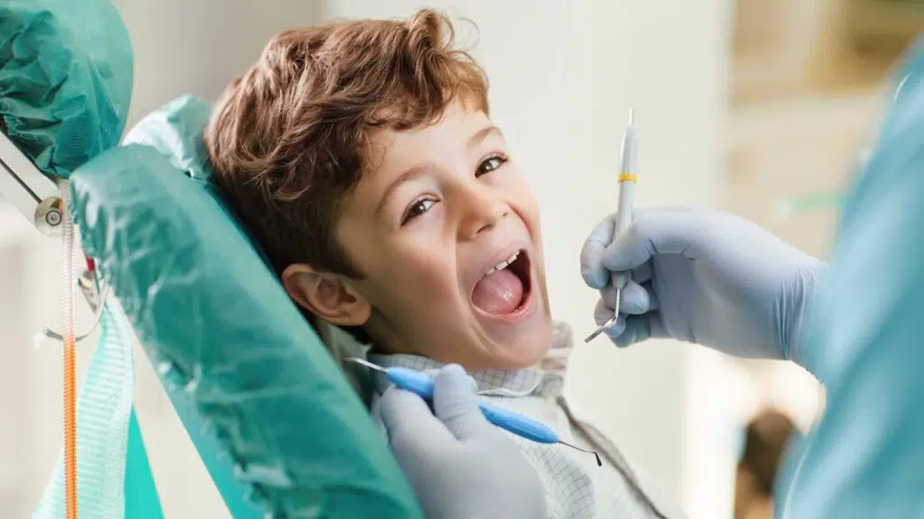kid with mouth open on his first pediatric dental office visit