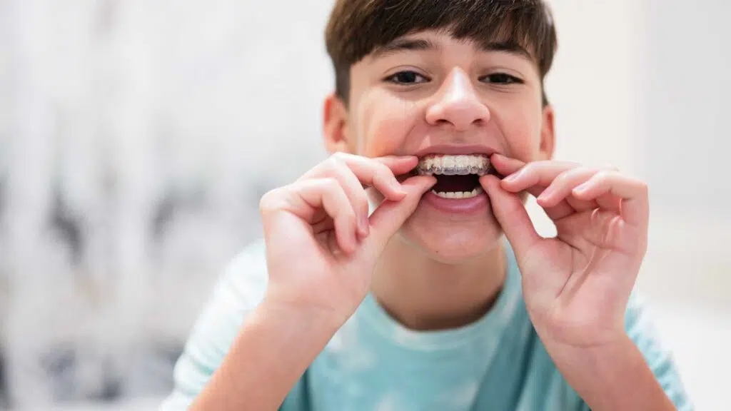 teen holding up braces after an Orthodontic Evaluation